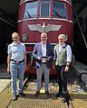 Wolfgang Ihrlich (Museumsleiter DB Museum Koblenz), Rainer Landwehr (CEO PIKO Spielwaren GmbH) und Matthias Fröhlich (Produktmanager PIKO Spielwaren GmbH) mit dem PIKO H0-Modell der Baureihe 119 vor der Museumslokomotive E 19 12 im DB Museum; Quelle: PIKO Spielwaren GmbH