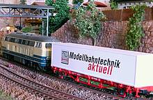 Eine Diesellok zieht einen Containertragwagen Typ Lgs579 (Nenngröße H0, Hersteller PIKO), beladen mit einem 40-Fuß-Container, zum nächsten Containerterminal
