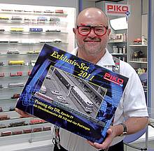 Herr Dr. Wilfer präsentiert das exklusiv zum „Tag der Offenen Tür“ in limitierter Auflage gefertigte und in einer hochwertigen Holzschatulle verpackte Zugset Postzug DR Ep. IV, welches im Vorfeld des Events bereits an den Handel ausgeliefert wurde, den anwesenden Journalisten
