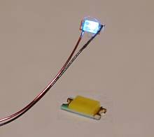 SMD-Leuchtdiode mit angelötetem Kuperlackdraht beleuchtet sowie eine einzelne SMD-LED