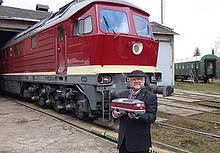 PIKO Inhaber Dr. René F. Wilfer posiert mit dem neuen Modell der Gartenbahn-Diesellok BR 132 vor dem imposanten Original.