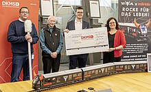 Der glückliche Käufer Philipp Schlampp (3. von links) erhält von Märklin Geschäftsführer Wolfrad Bächle (2. von links) ein außergewöhnliches Sammlerstück. Der exklusive Wacken-Teufelszug erzielte auf der Auktionsplattform Catawiki einen Erlös von 12.000.- Euro, der von Märklin komplett als Spende an die DKMS geht. Freuen sich ebenfalls über den Erfolg: Christophe Hendriks Franssen (Catawiki-Expert Model Trains, ganz links mit symbolischem Wattestäbchen) und Andrea Autenrieth (Abteilungsleiterin Spenderneugewinnung DKMS, ganz rechts).
